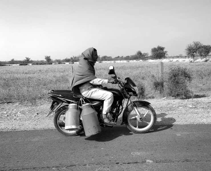 A man riding a motorcycle on a dirt road.