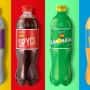 Four different bottles of soda on a colorful background.