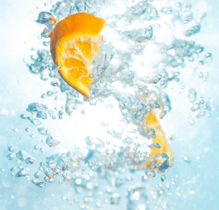 Oranges splashing in the water.