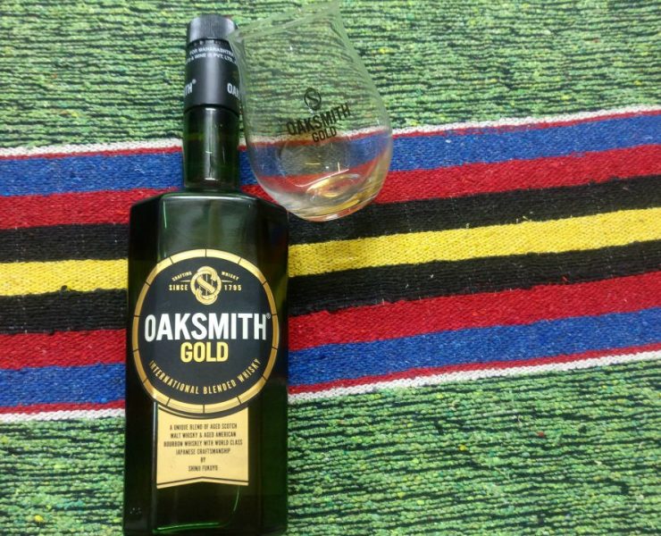 bottle and glass of scotch whisky on green background