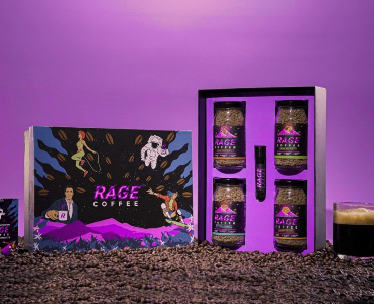 Rage Coffee gift pack with coffee jars, a small box, and a shot tube on a bed of coffee beans. A cup of coffee is on the right. The background is purple with colorful, dynamic graphics.