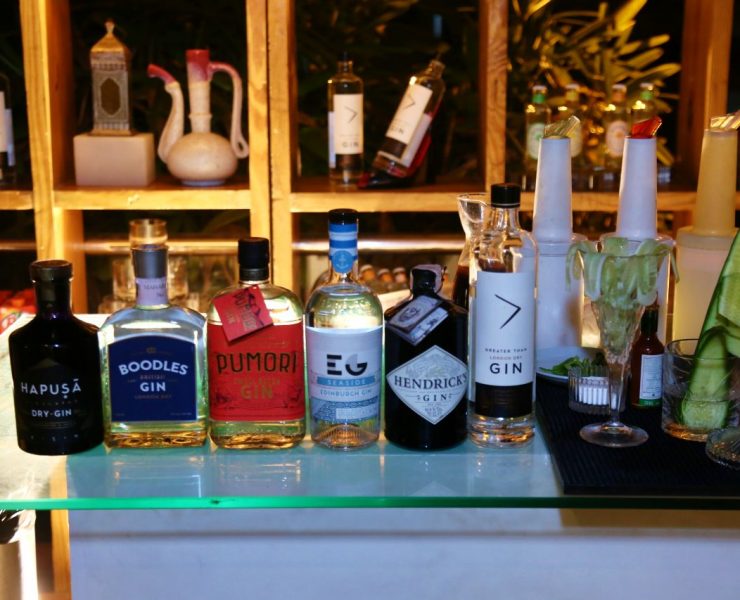 A selection of gin bottles displayed on a bar counter, including various brands.