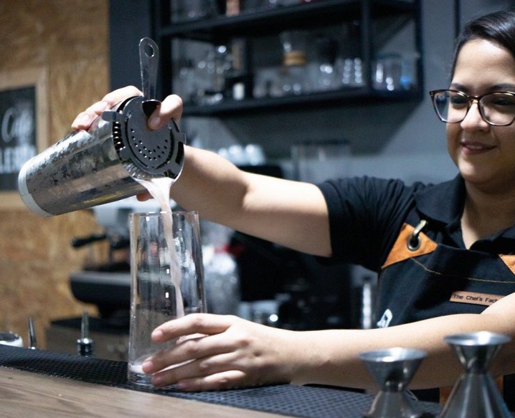 female bartender behind the bar pouring drinks